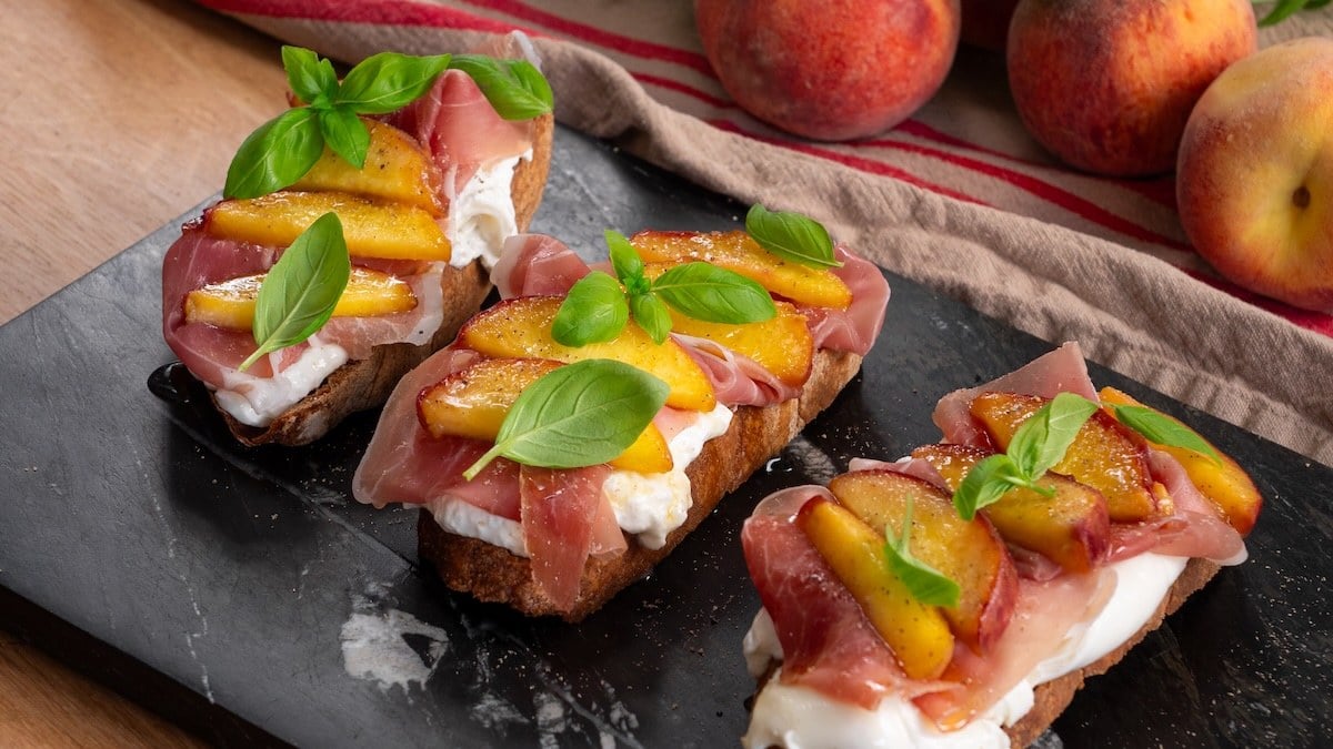 Pêches rôties, jambon cru et burrata : une bruschetta qui sent bon le soleil en seulement 5 minutes !