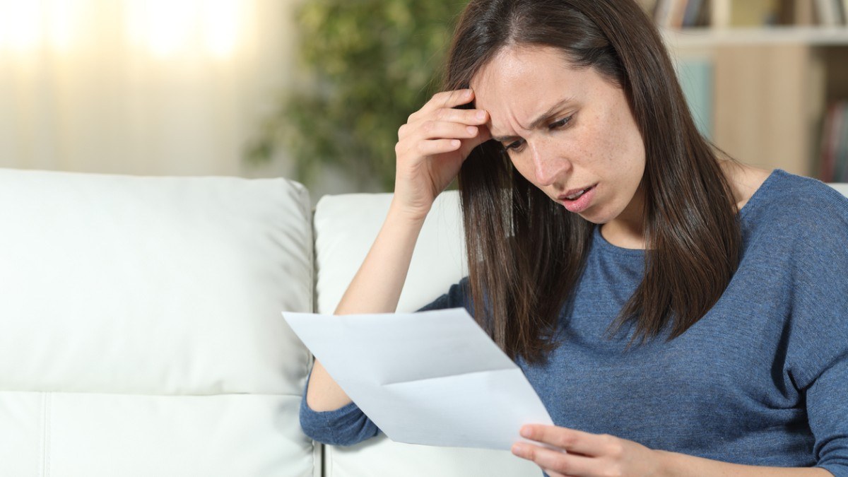 Une femme inqui&egrave;te lit un document