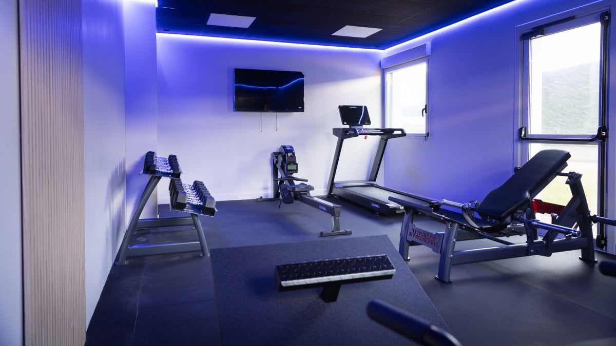 une salle de sport à la maison avec haltères et tapis de course