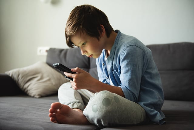 Un petit garçon qui joue sur son smartphone