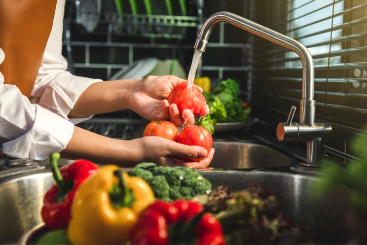 Une personne passe des tomates sous l'eau