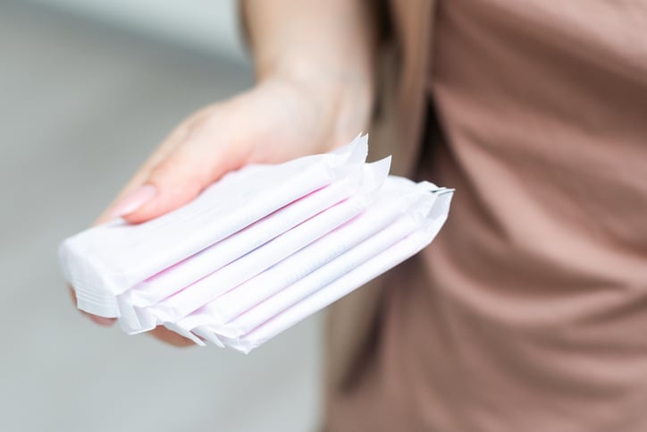 Une femme tient des serviettes hygiéniques dans sa main