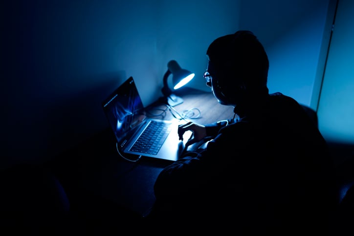 Un homme sur un ordinateur la nuit