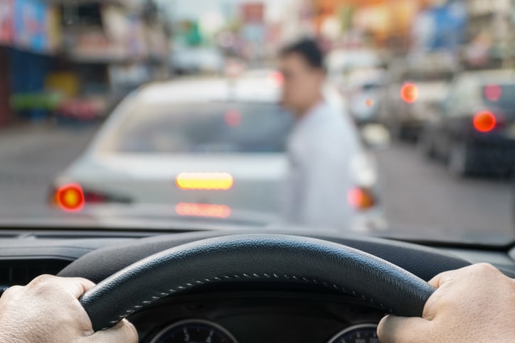 Un piéton passe devant une voiture