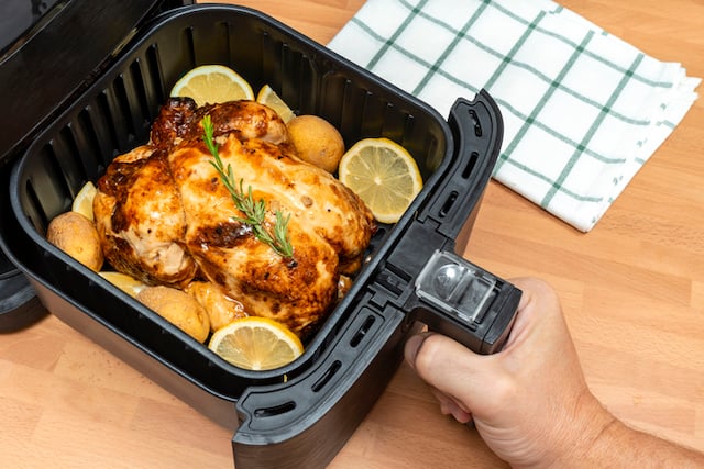 Un poulet en train de cuire dans un Airfryer