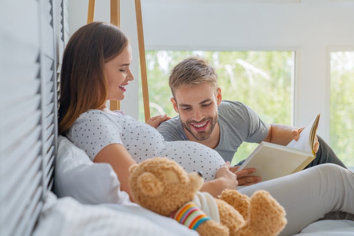 Un homme regarde le ventre rond de sa femme enceinte
