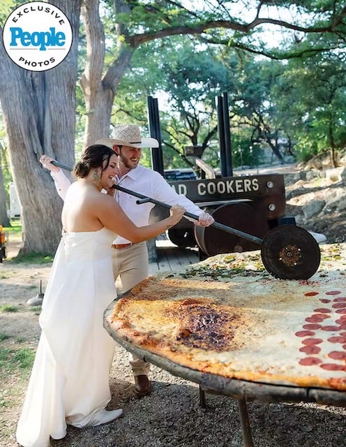 Les mariés en train de couper la pizza géante
