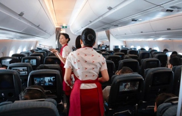 Deux hôtesses de l'air en train de servir les passagers d'un avion