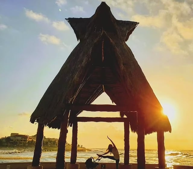 Elizabeth Shores en train de faire du yoga sur une plage