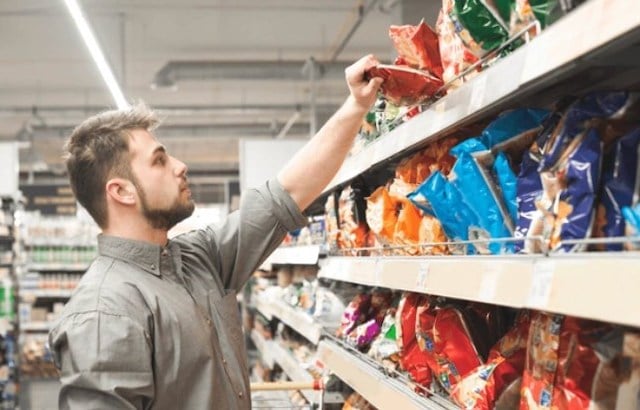 Un homme qui choisit un paquet de chips