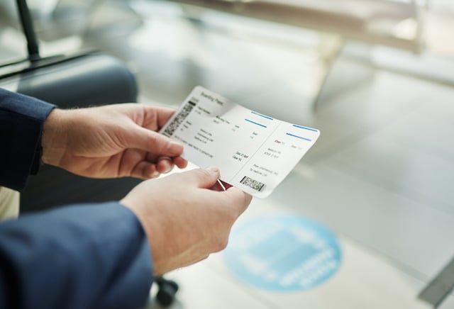 Un passager qui tient son billet d'avion