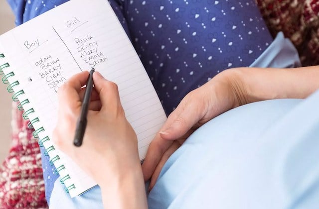 Une future maman qui écrit une liste de prénoms