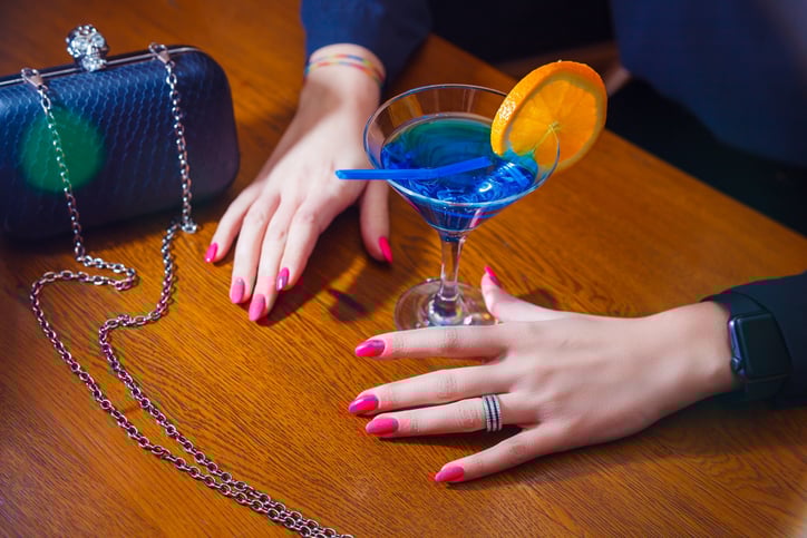 Une femme boit un verre dans un bar