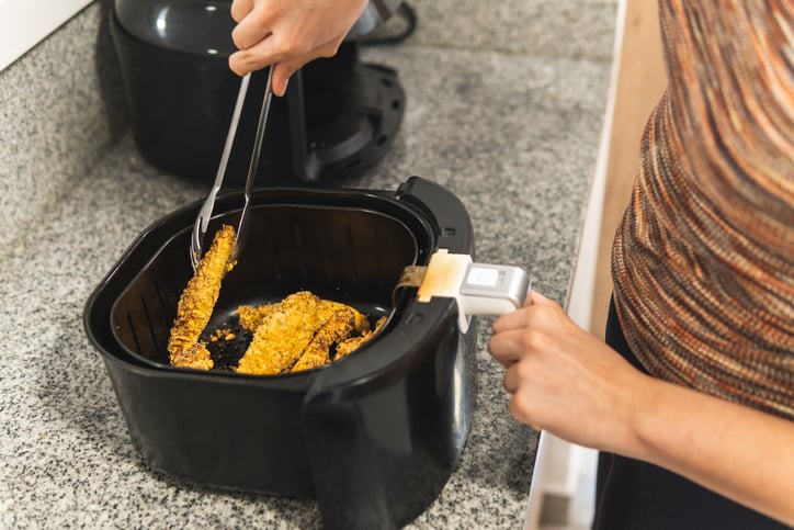 Une personne cuisine avec un airfryer