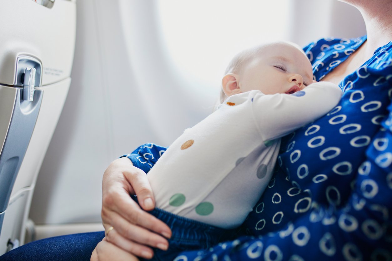 Un bébé dans les bras d'une femme dans un avion