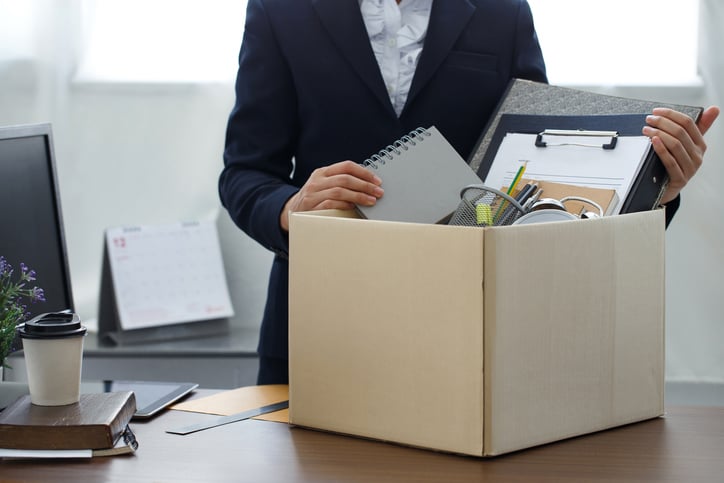 Une personne rassemble ses affaires dans un carton