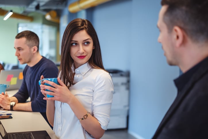 Une femme regarde son collègue avec intérêt