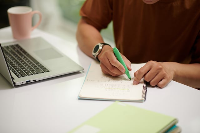 Une personne qui écrit sur un bloc-notes
