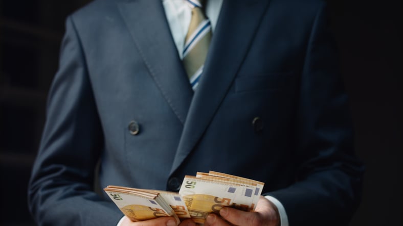 Un trader tient une liasse de billets