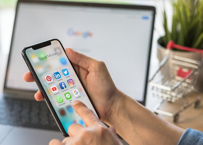 Un homme consulte ses différents comptes google sur son smartphone et son ordinateur