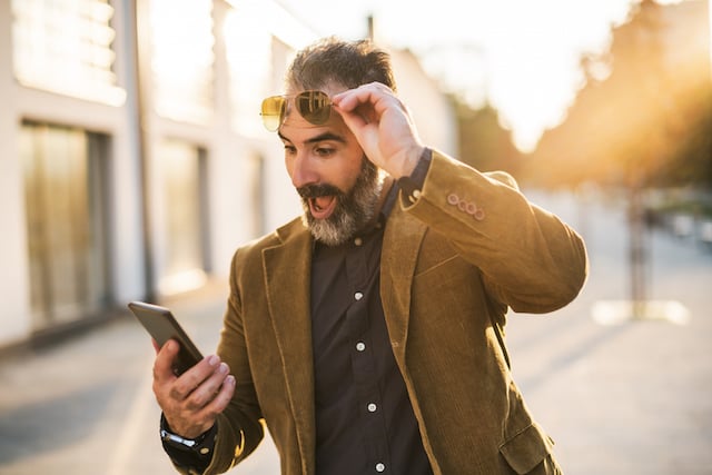 Un homme heureux qui consulte son téléphone