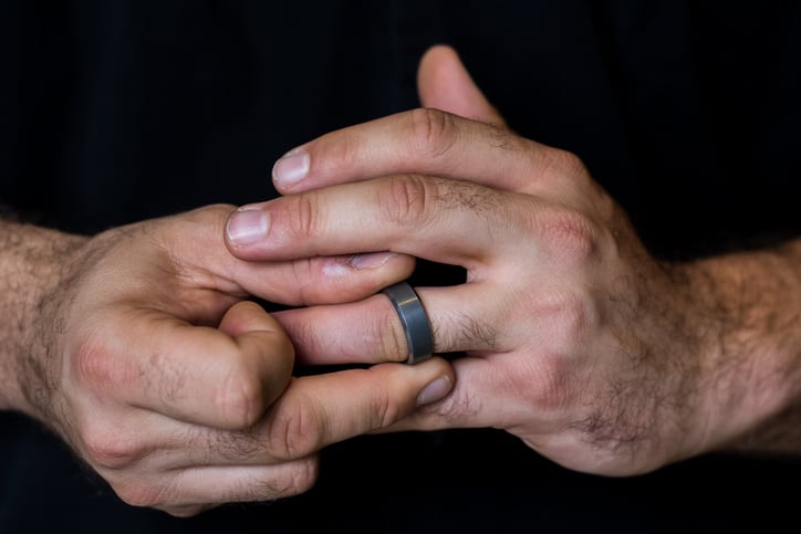 Un homme porte une bague noire