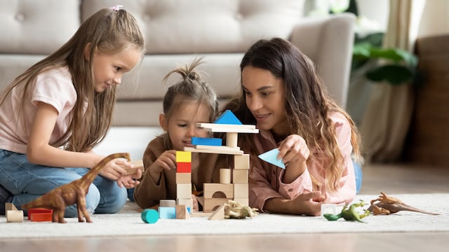 Une jeune femme en train de jouer avec deux enfants