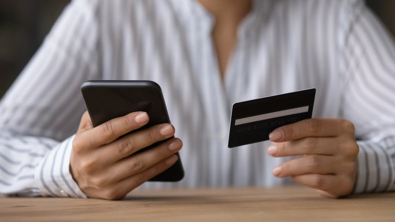 Une femme donne ses coordonnées bancaires au téléphone