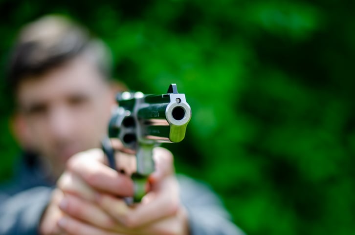 Un homme pointe son revolver sur une cible