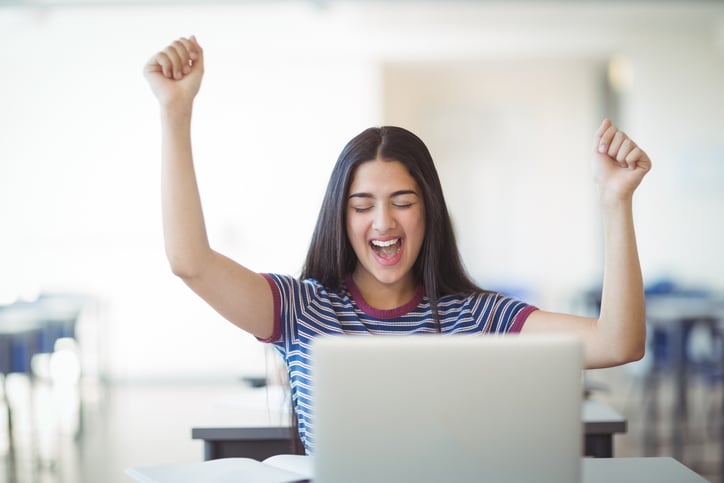 Une jeune femme heureuse devant son ordinateur
