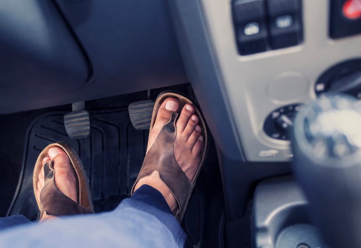 Une personne conduit en tongs