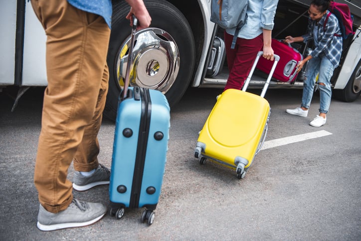Des voyageurs en car avec leurs valises
