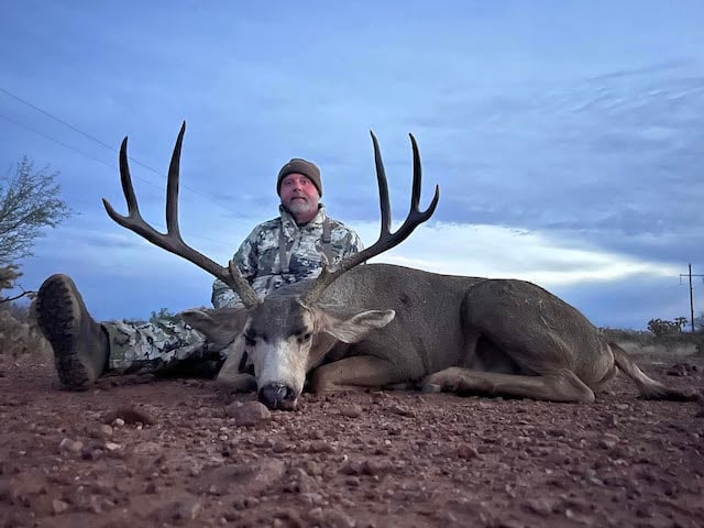 Asher Watkins en train de poser avec un trophée de chasse