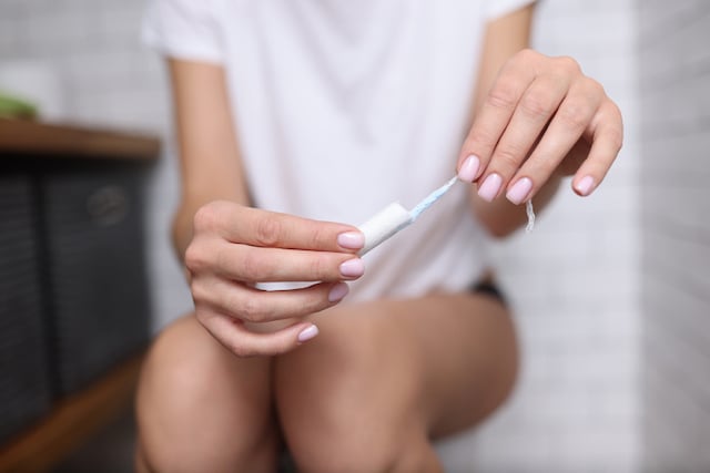 Une femme s'apprêtant à mettre un tampon