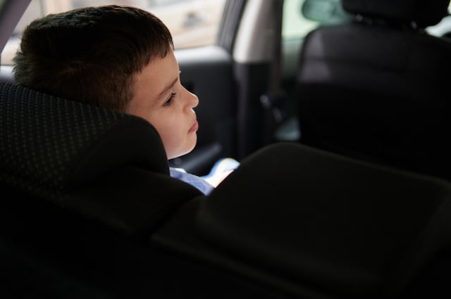 Un petit garçon pensif dans une voiture