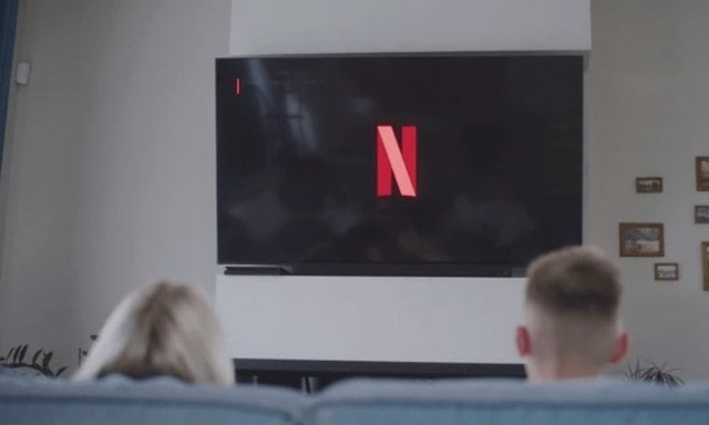 Deux personnes devant le logo Netflix
