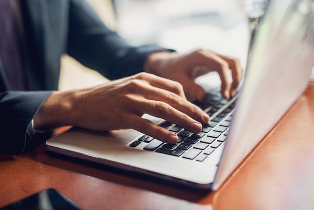 Homme qui tape sur un clavier d'ordinateur