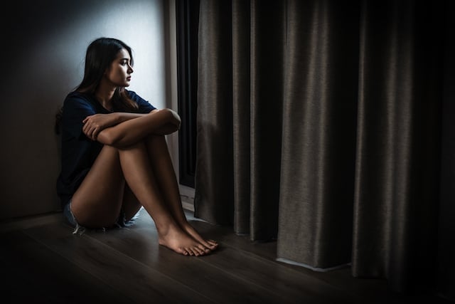 Femme d'origine asiatique qui regarde par la fenêtre