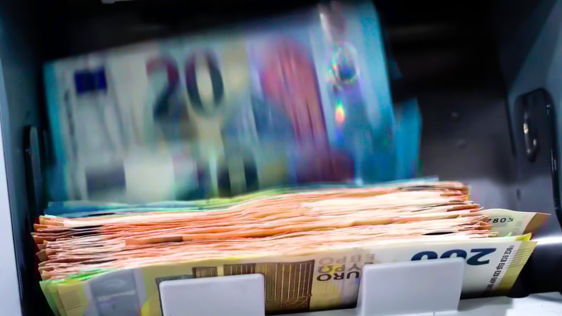 Des billets sortent du distributeur