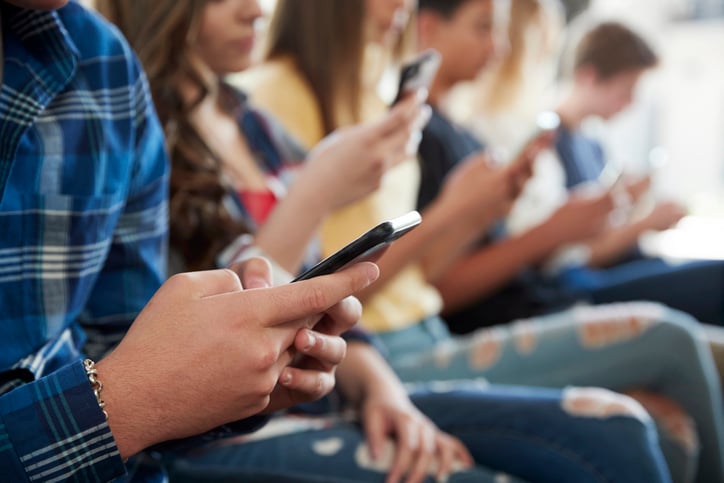 Des jeunes utilisent leur téléphone