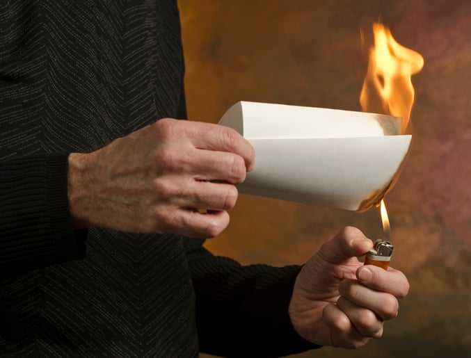 Un homme allume un papier pour mettre le feu