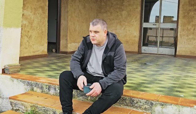 Jonathan Smith assis sur la terrasse de sa villa