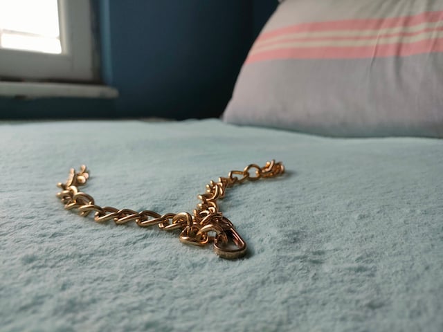Une chaîne en or posée sur un lit