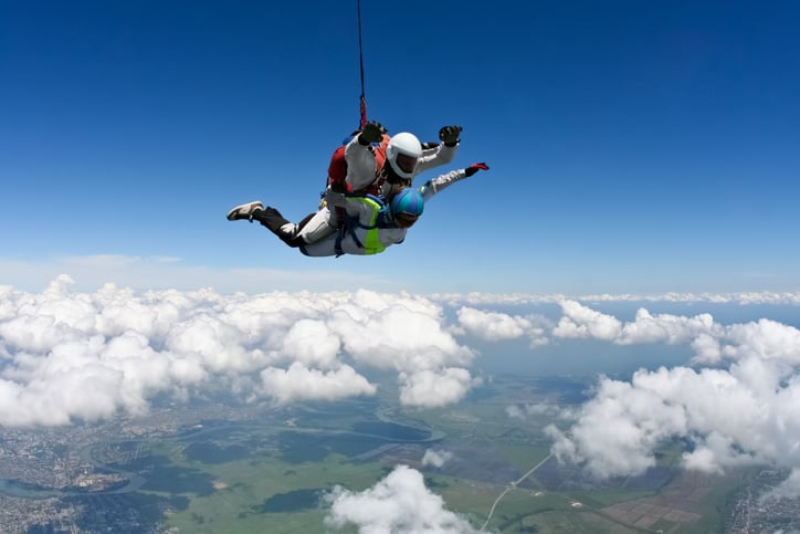 Un homme passant son baptême de l'air en parachute, avec un moniteur