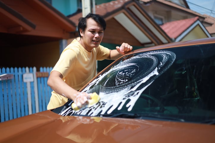 Un homme lave sa voiture