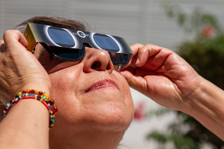 Une personne regarde l'éclipse avec des lunettes