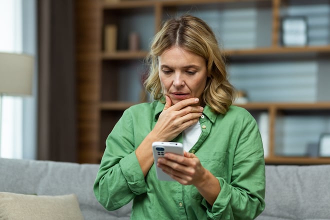 Une femme triste en train de lire un sms