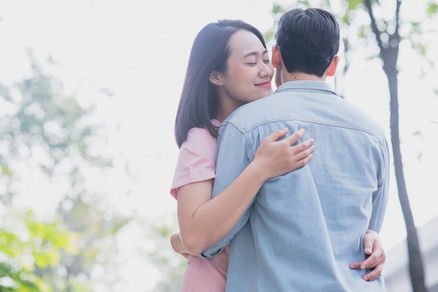 Un couple asiatique qui s'enlace dans un parc