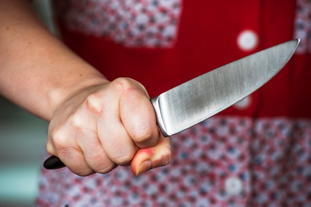 Une femme tenant fermement un couteau