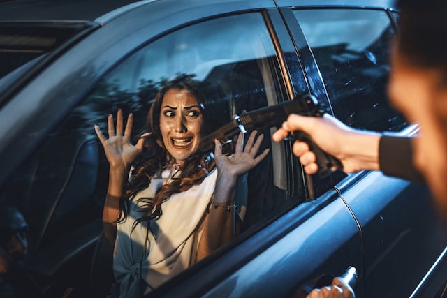 Un homme qui braque un pistolet sur une automobiliste 
